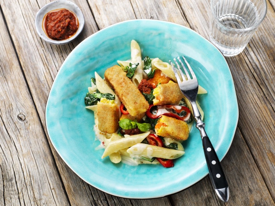 foto van penne met veggie sticks en spinazie