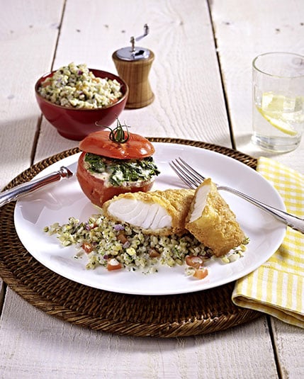 Gepaneerde kabeljauw suprême met gevulde tomaten en gehakte spinazie