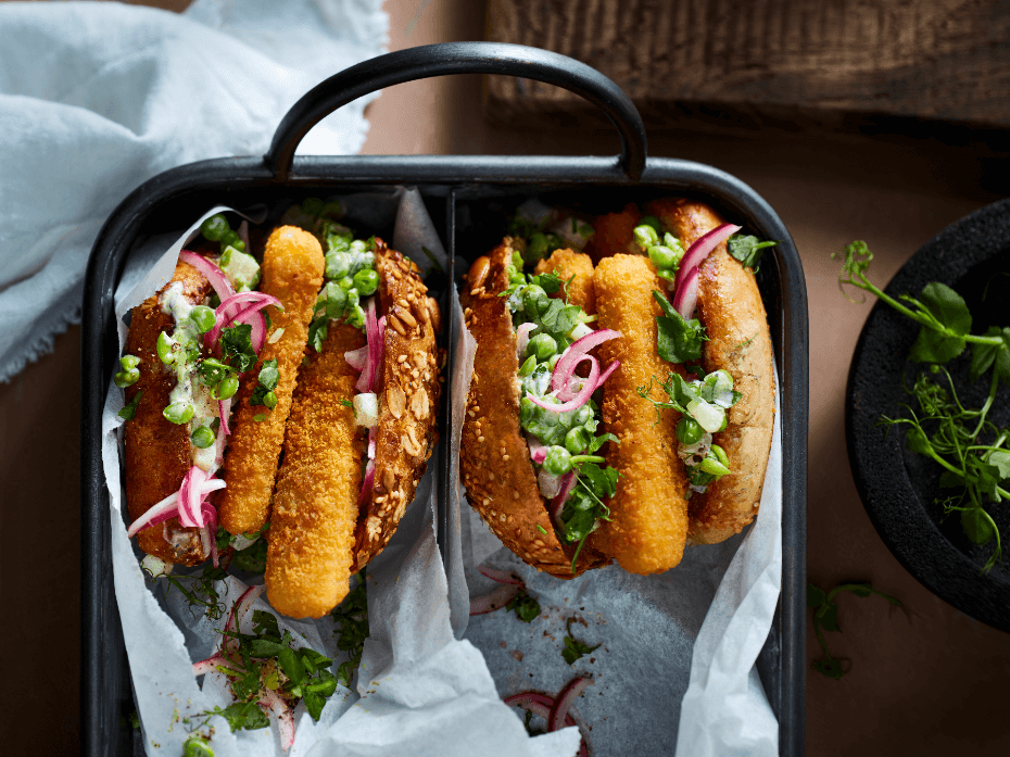 Vegetarische fish stick burger met erwten, augurken en rode ui