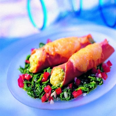 Hamrolletjes op een bed van bladspinazie